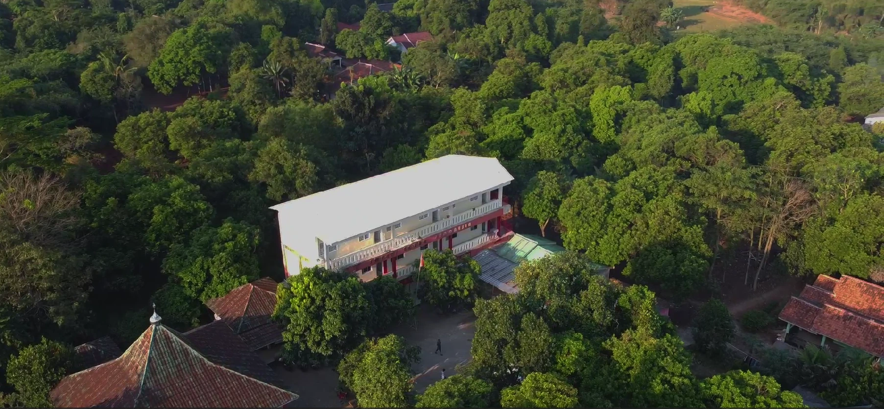 Gedung sekolah PPTQ An-Nur Indonesia dengan taman hijau dan area pendidikan modern